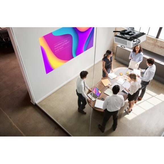 Modern office meeting room showing projected presentation with team gathered around conference table